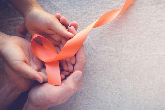 Adult and child hands holding orange Ribbons, Multiple sclerosis awareness,